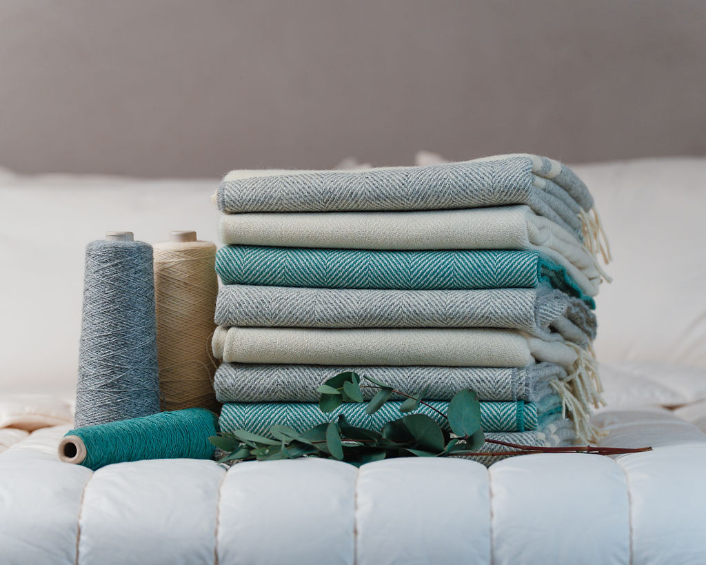 Image with yarn and finished woven blankets from Dooley Wool