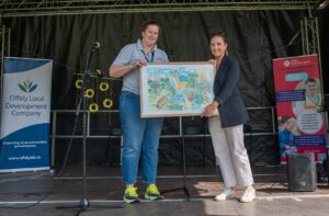 This is a photo of Louise giving someone a picture in frame at the event
